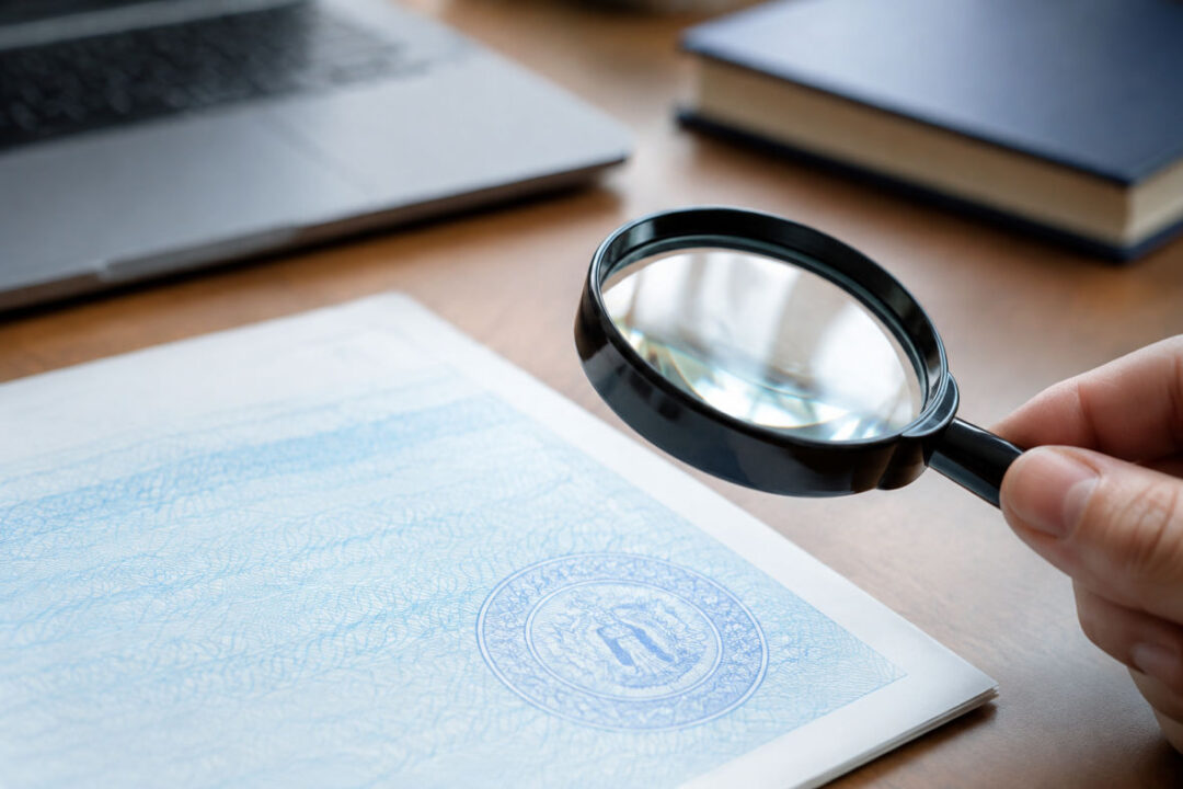 Loupe posée sur un document pour vérifier l'authenticité du casier judiciaire néant